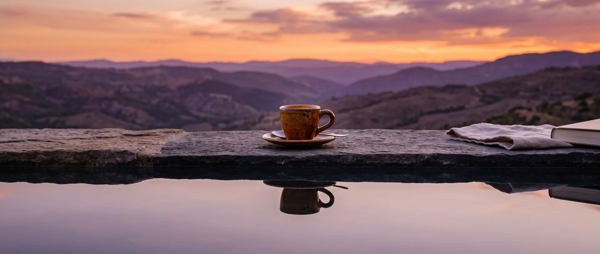 Tazzina in ceramica su una terrazza di pietra al tramonto riflessa nell'acqua
