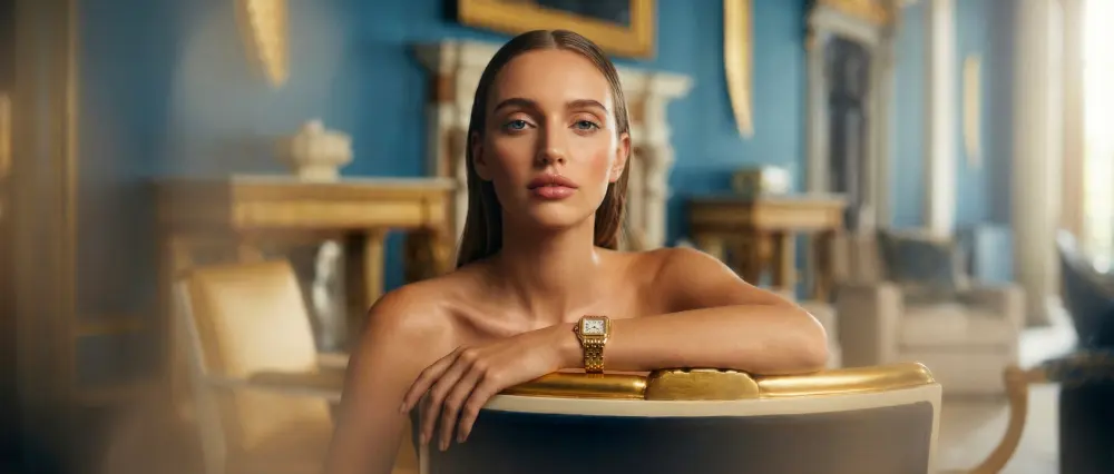 Modella con un orologio d'oro in un salone blu e oro