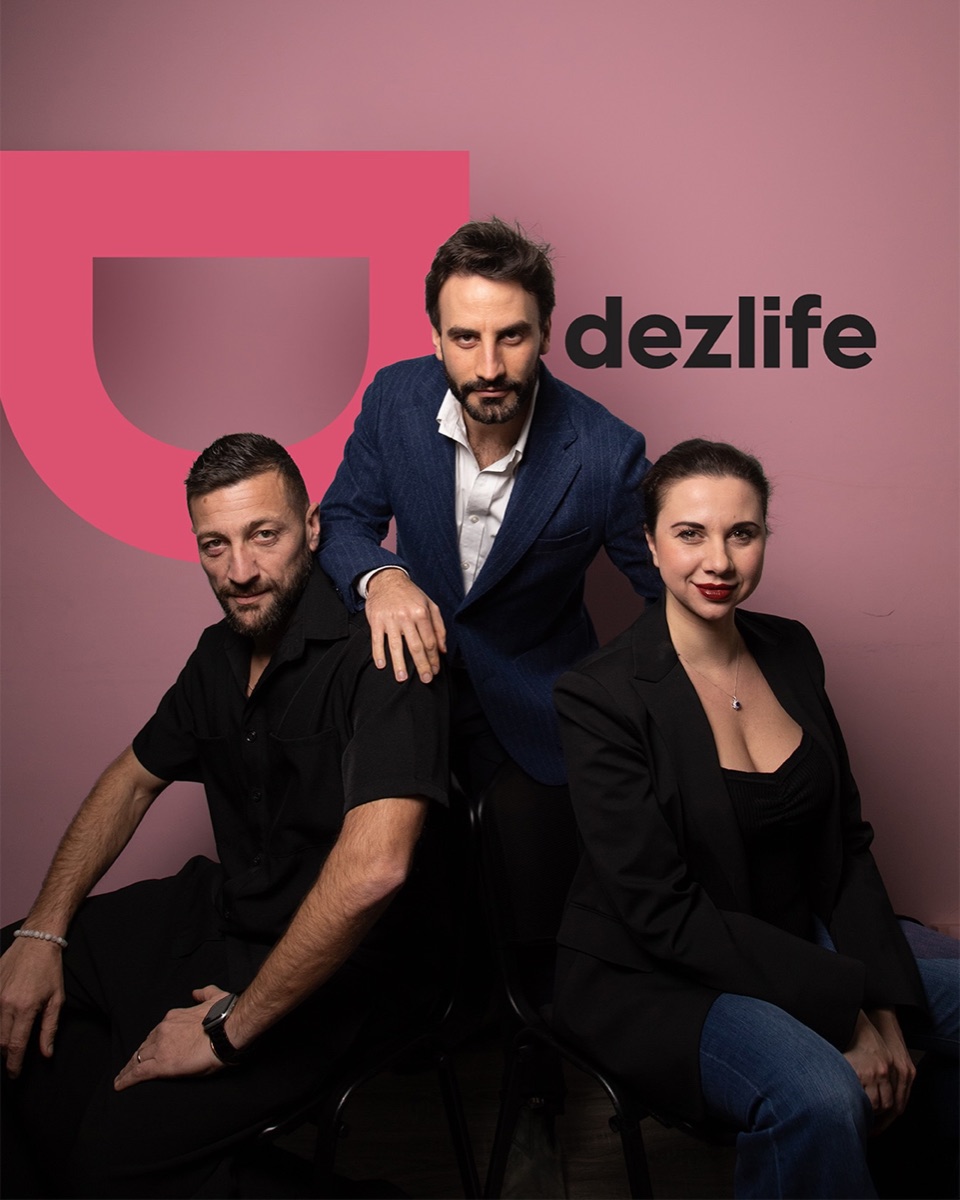 Il team di Dezlife: tre persone in posa davanti al logo Dezlife